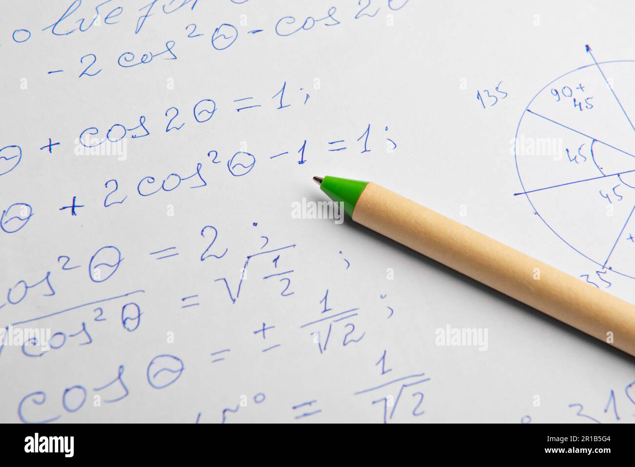 Papier avec calculs mathématiques écrits et stylo, gros plan Banque D'Images