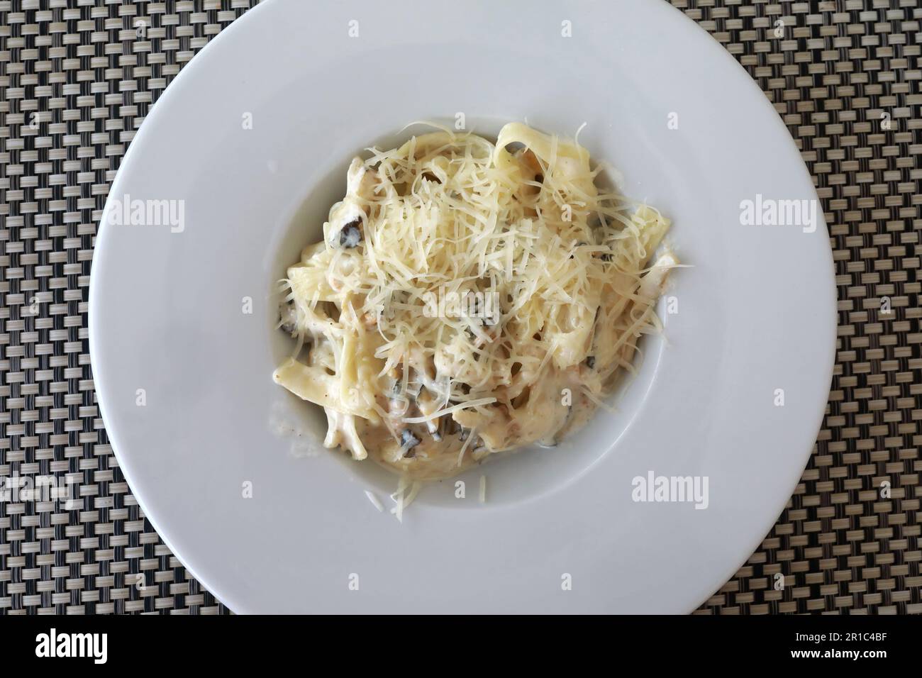 Pâtes carbonara aux champignons sur une assiette blanche au restaurant Banque D'Images
