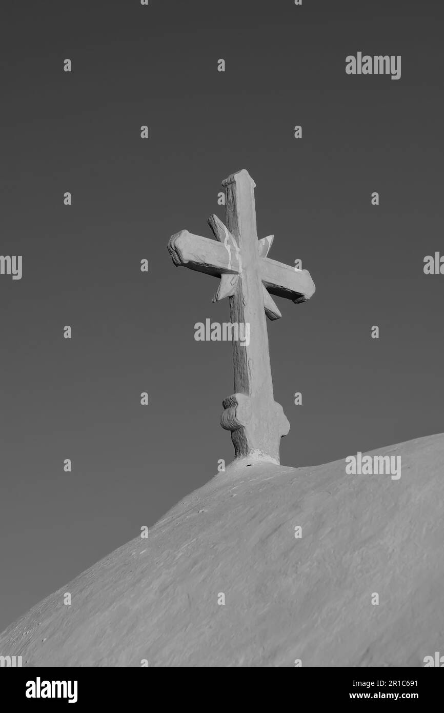 Une croix sur le dessus d'une église orthodoxe blanchie à la chaux dans iOS Grèce et un ciel bleu dans le fond dans iOS Grèce en noir et blanc Banque D'Images