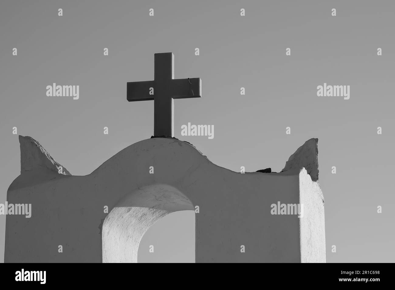 Une croix sur le dessus d'une église orthodoxe blanchie à la chaux dans iOS Grèce et un ciel bleu dans le fond dans iOS Grèce en noir et blanc Banque D'Images
