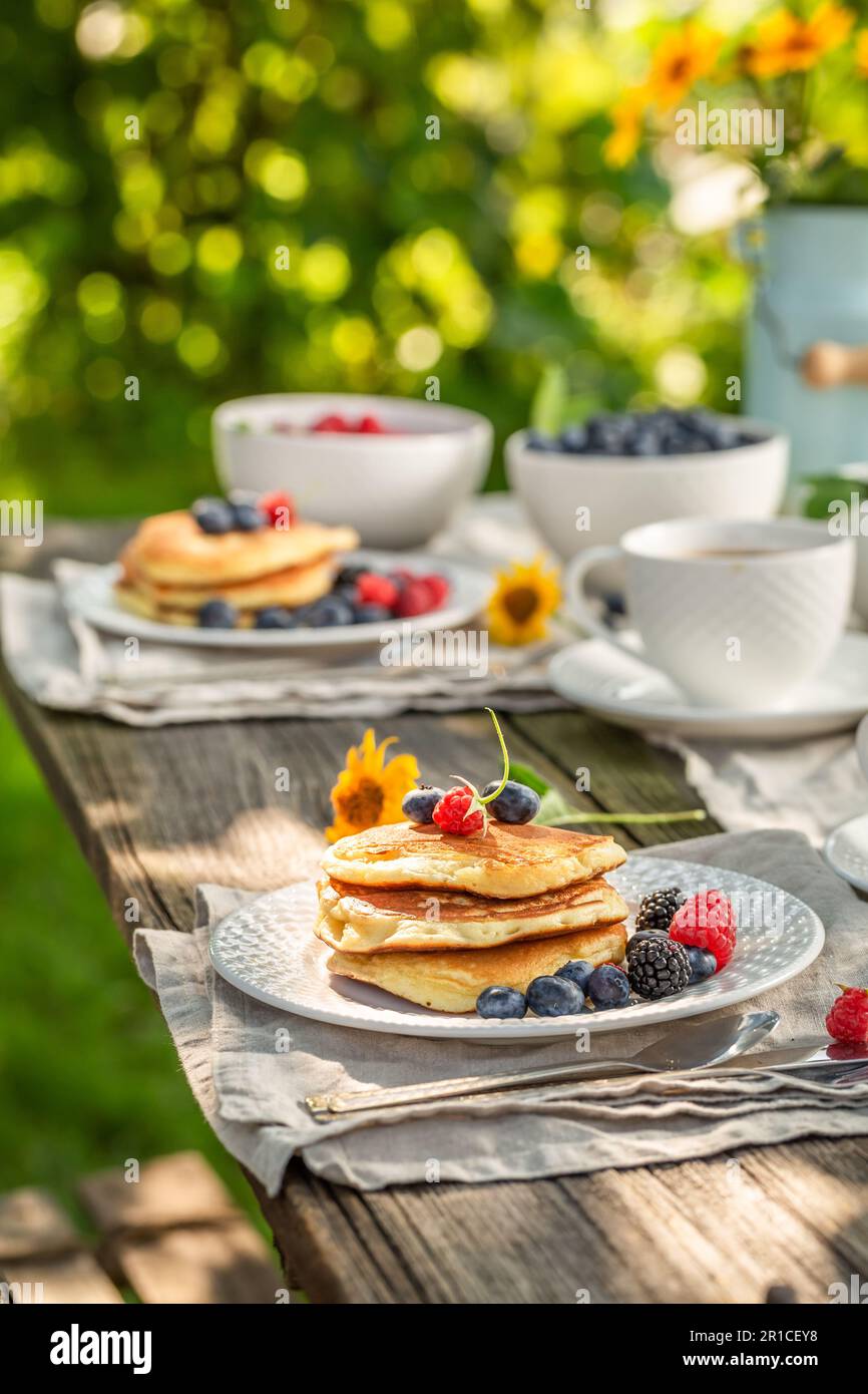 Crêpes américaines fraîches et chaudes servies avec café dans le jardin. Petit déjeuner dans le jardin de printemps. Banque D'Images