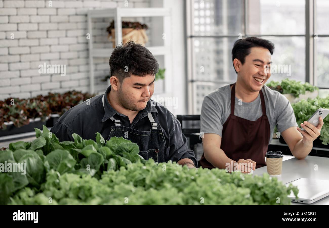 Le vendeur de légumes a fêté avec son personnel la réception d'un grand nombre de commandes par téléphone. Cela a le potentiel de générer des revenus élevés et pro Banque D'Images