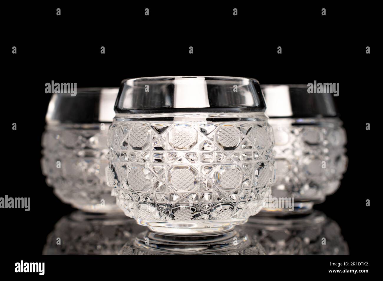 Trois verres en cristal, macro, isolés sur fond noir. Banque D'Images