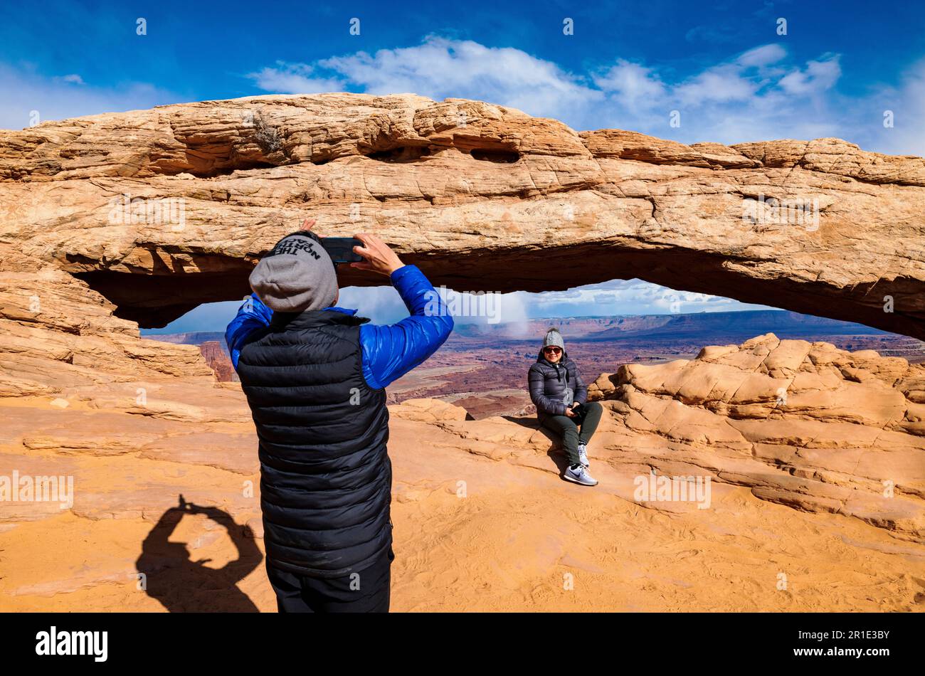 Touriste asiatique photographiant sa femme à Mesa Arch ; Island in the Sky ; Parc national de Canyonlands ; Utah ; États-Unis Banque D'Images