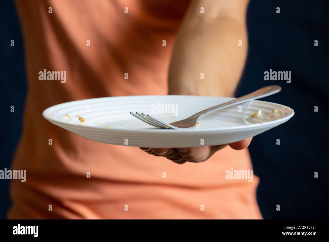 assiette blanche sale avec une fourchette dans la main d'une fille Banque D'Images