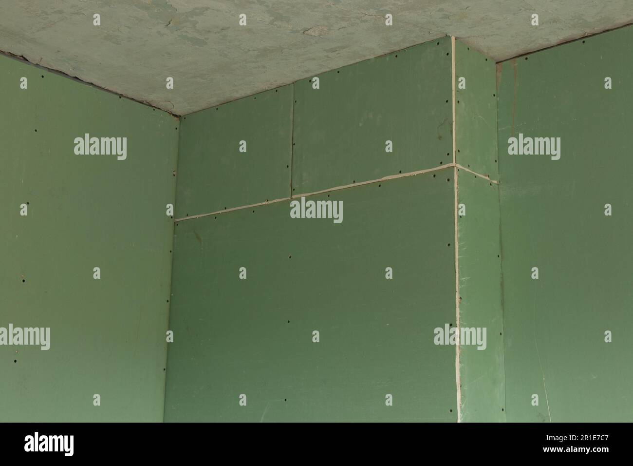 plaque de plâtre verte sur le mur, réparation de la salle Banque D'Images