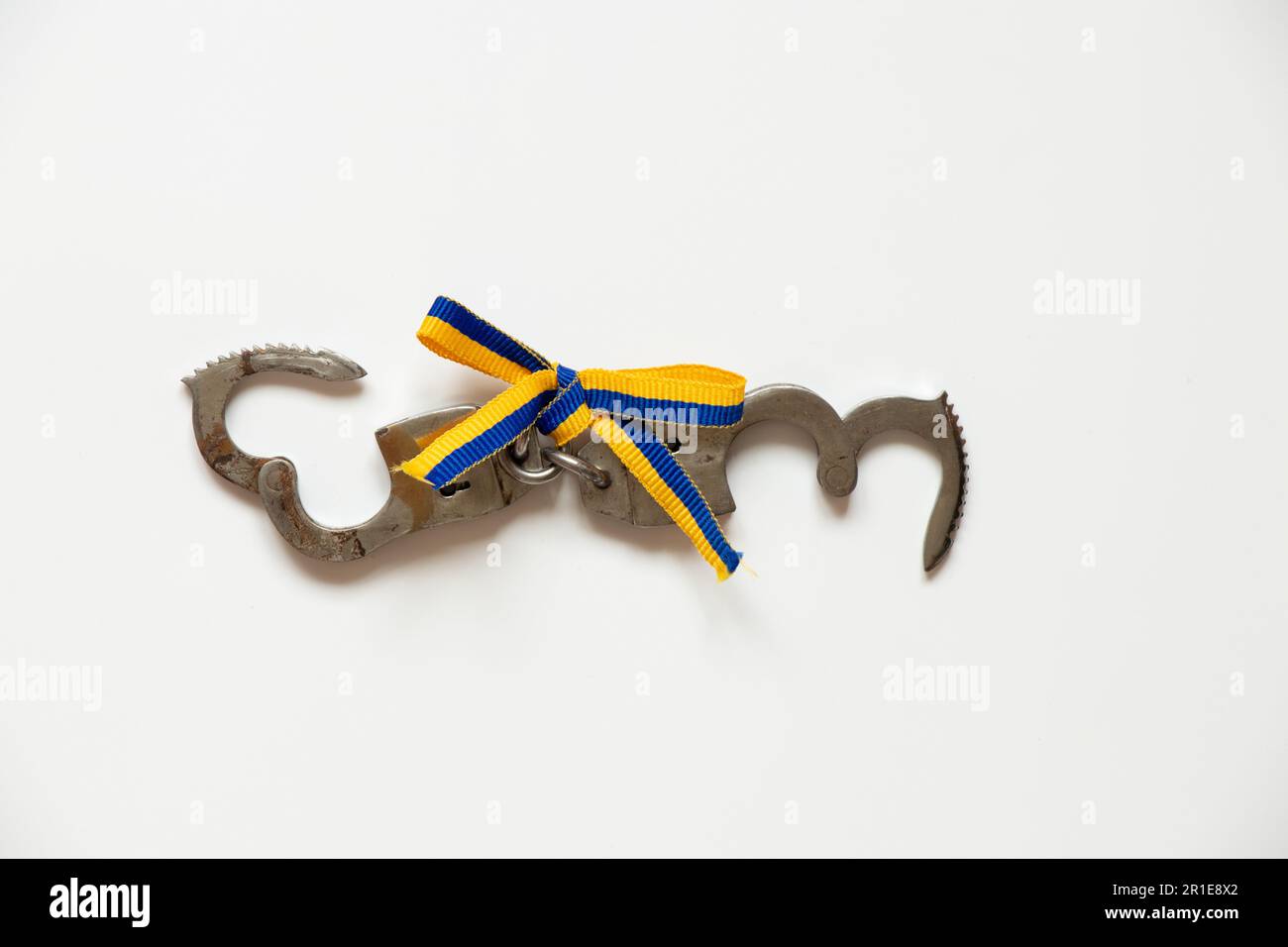 Menottes attachées avec un ruban du drapeau de l'Ukraine sur un fond blanc, la justice en Ukraine Banque D'Images