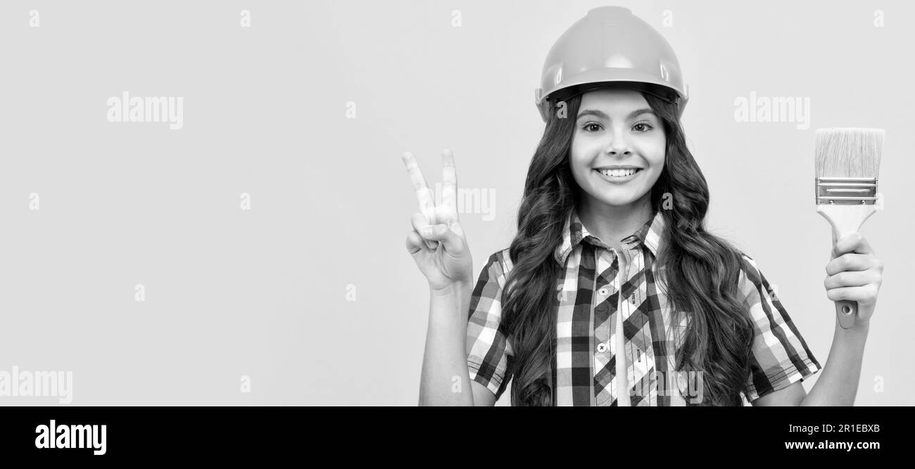 Rénovation enfant, bonne fille de l'adolescence dans la construction casque tenir la peinture brosse montrer la paix geste, la décoration. Affiche horizontale pour le constructeur d'enfants Banque D'Images
