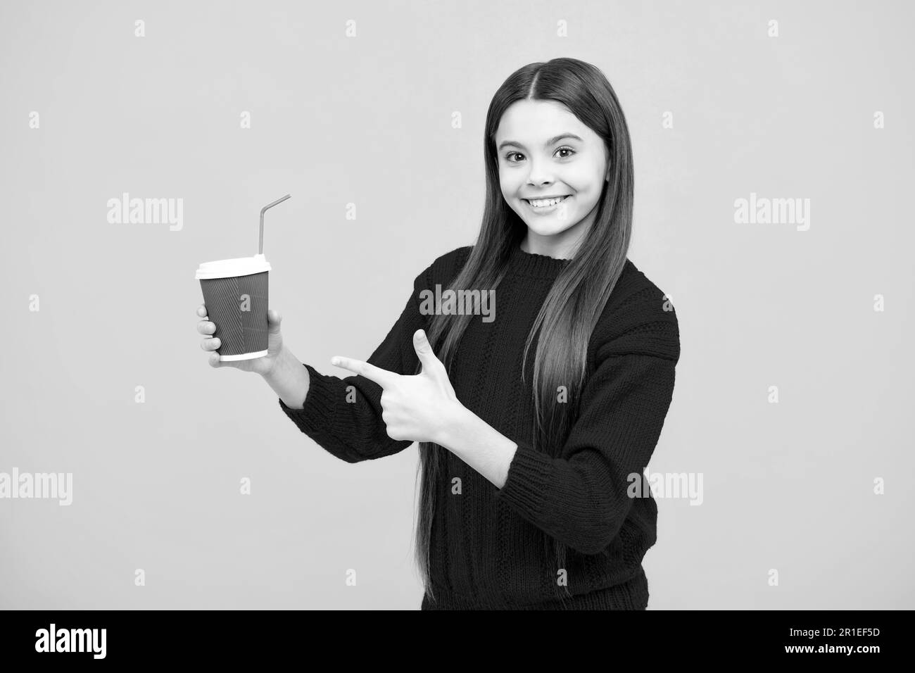 Enfant adolescent avec une tasse de café isolée sur fond jaune studio. Boisson à emporter pour fille Banque D'Images