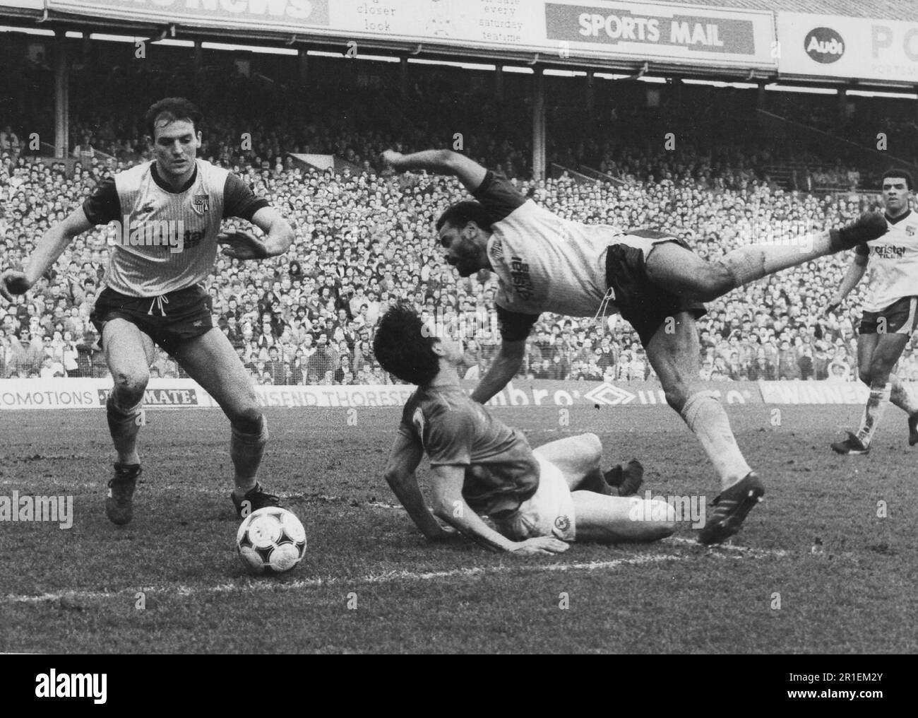 PAUL MARINER DE PORTSMOUH EST RENVERSÉ PAR GEORGE BERRY DE STOKE POUR GAGNER UNE PÉNALITÉ,1986. PIC MIKE WALKER 1986 Banque D'Images