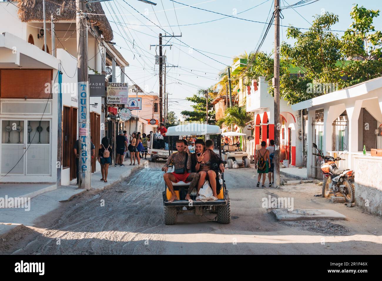 Les touristes montent une voiturette de golf dans les rues boueuses de Isla Holbox, au Mexique Banque D'Images