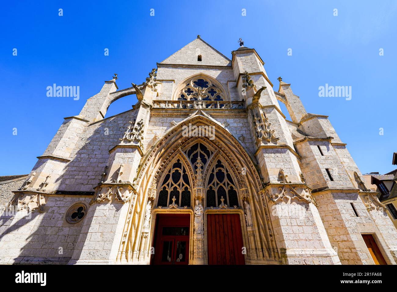 Façade de l'église gothique notre-Dame de la Nativité avec des contreforts volants dans la ville médiévale de Moret-sur-Loing en Seine et Marne, France Banque D'Images