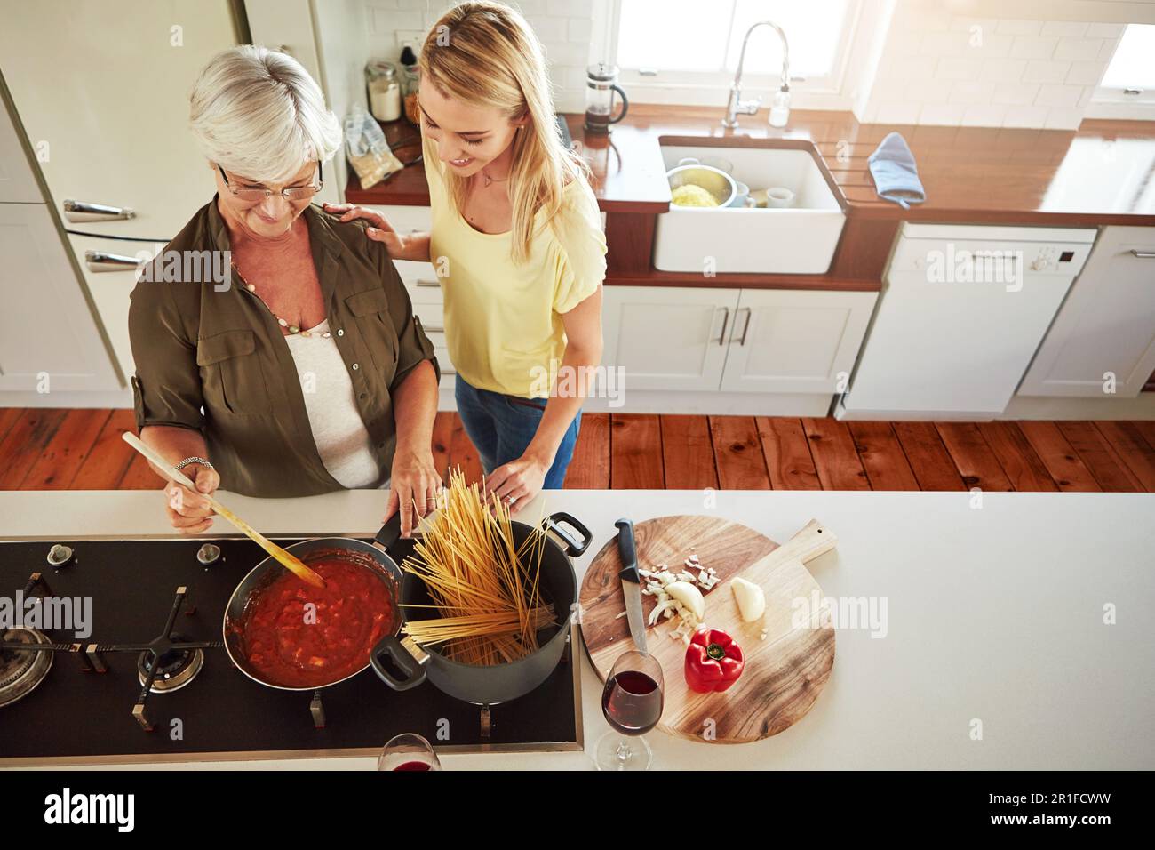 Enseignement, femme ou mère cuisine nourriture pour un régime végétalien sain avec l'amour dans la maison familiale. Jeune fille, enfant supérieur ou adulte apprenant ou aidant Banque D'Images