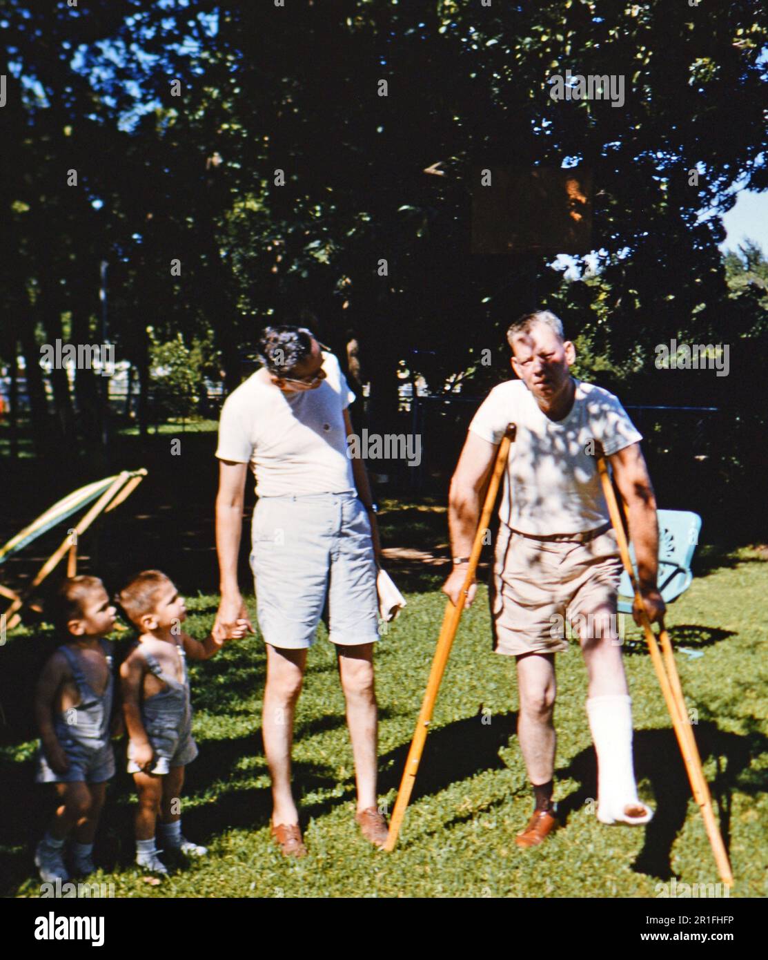 Homme avec une jambe inférieure cassée debout avec des béquilles ca. 1958 Banque D'Images