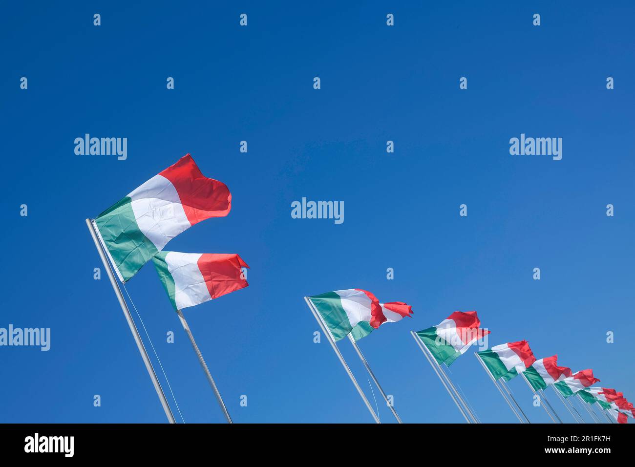 Rangée de drapeaux italiens dans le vent contre ciel bleu clair Banque D'Images
