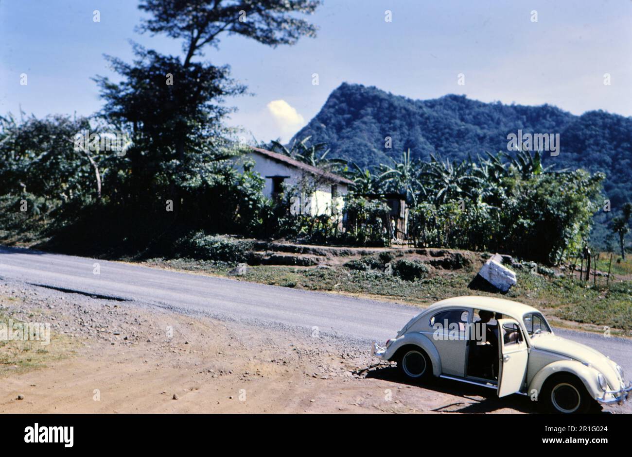Jaune Volkswagen Beetle garée sur le côté d'une route en Afrique du Sud rurale ca. 1966 Banque D'Images