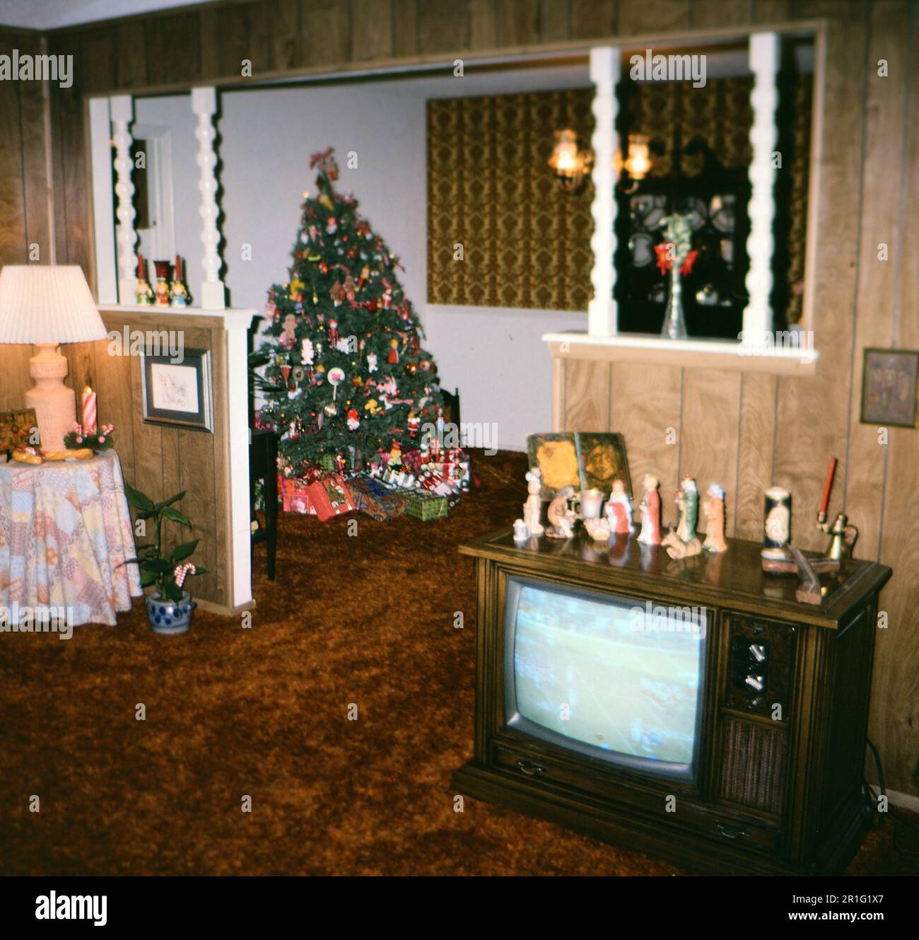 Un jeu de football joue sur une console TV dans un salon américain, un arbre de Noël dans la pièce suivante ca. 1978 Banque D'Images