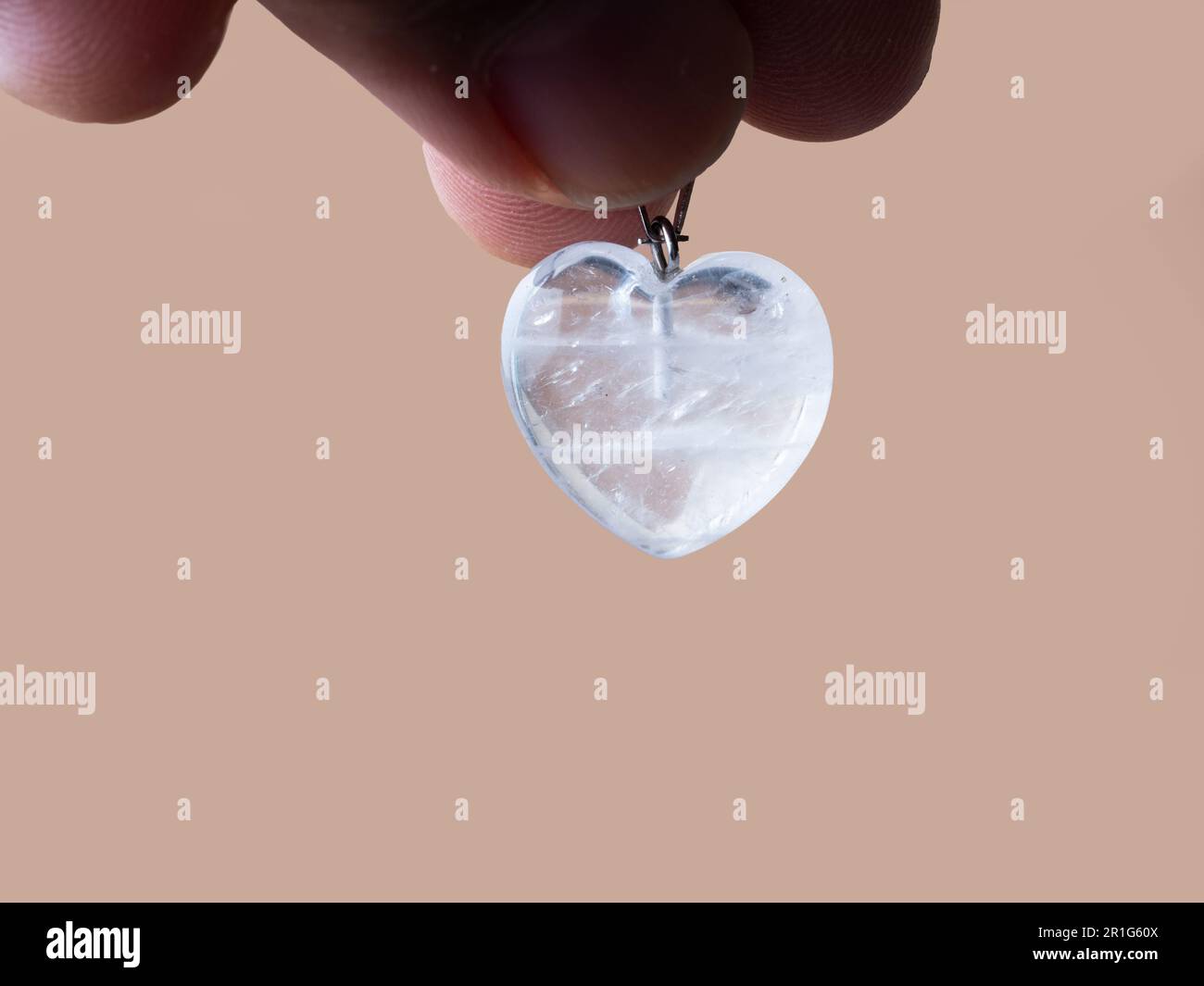 Suspension en forme de coeur cryatal blanc transparent sur fond marron Banque D'Images