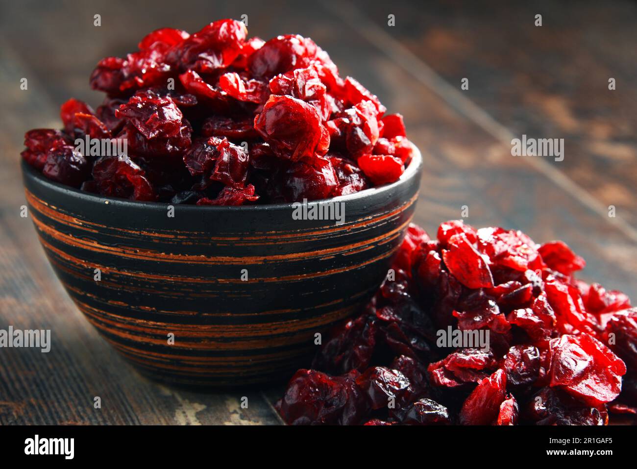 La composition avec bol de canneberges séchées sur table en bois Banque D'Images