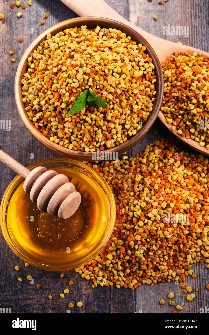 Bols avec du pollen d'abeille et le miel sur une table de cuisine. Suppléments nutritionnels Banque D'Images