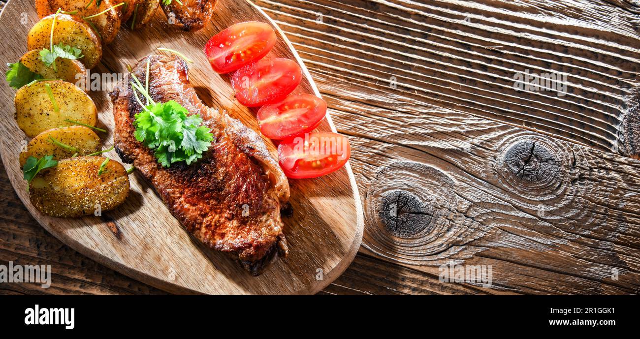 Steak de bœuf poêlé avec pommes de terre frites et tomates cerises Banque D'Images