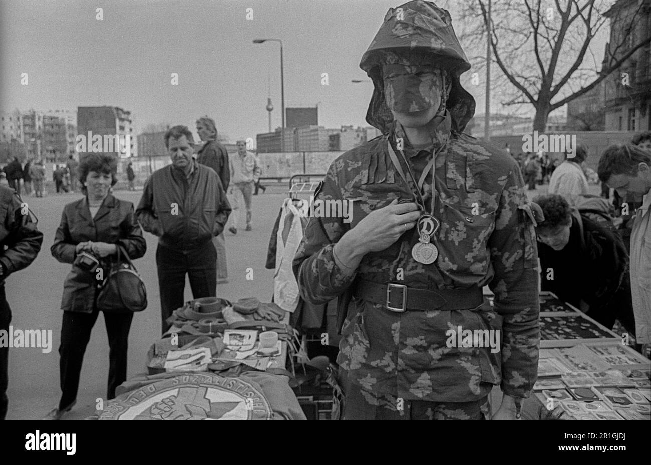 GDR, Berlin, 22.02.1990, vendeur en costume de camouflage NVA, avec médailles, casque d'acier, masque, rumage mural au Reichstag Banque D'Images