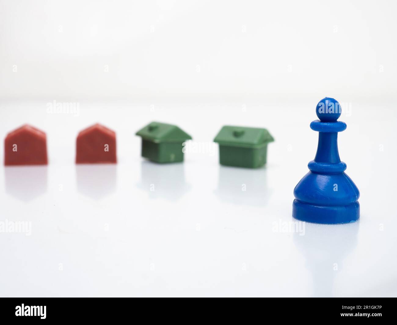 Maison miniature et pièce d'échecs bleu qui fait de plastique recyclé Banque D'Images