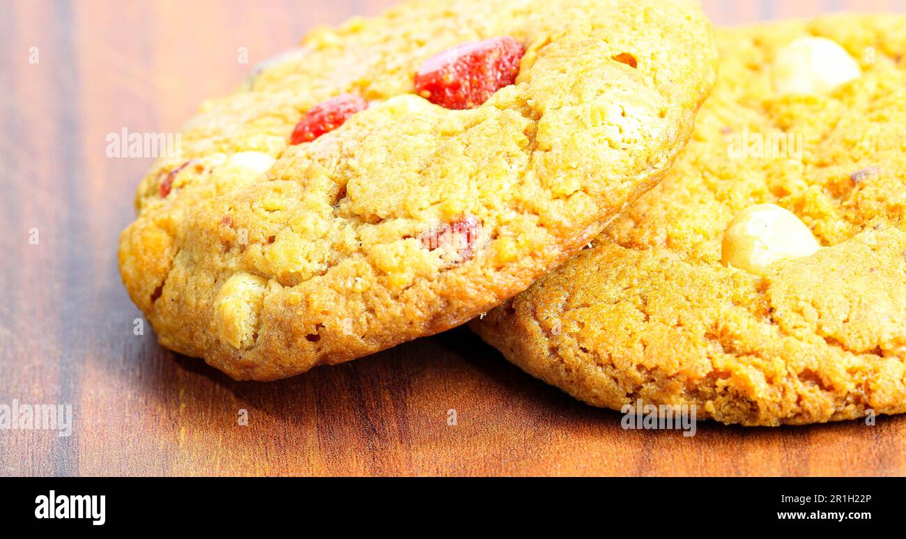 Biscuit doux au macadamia, biscuit à la fraise et biscuit aux amandes sur une assiette en bois. Banque D'Images
