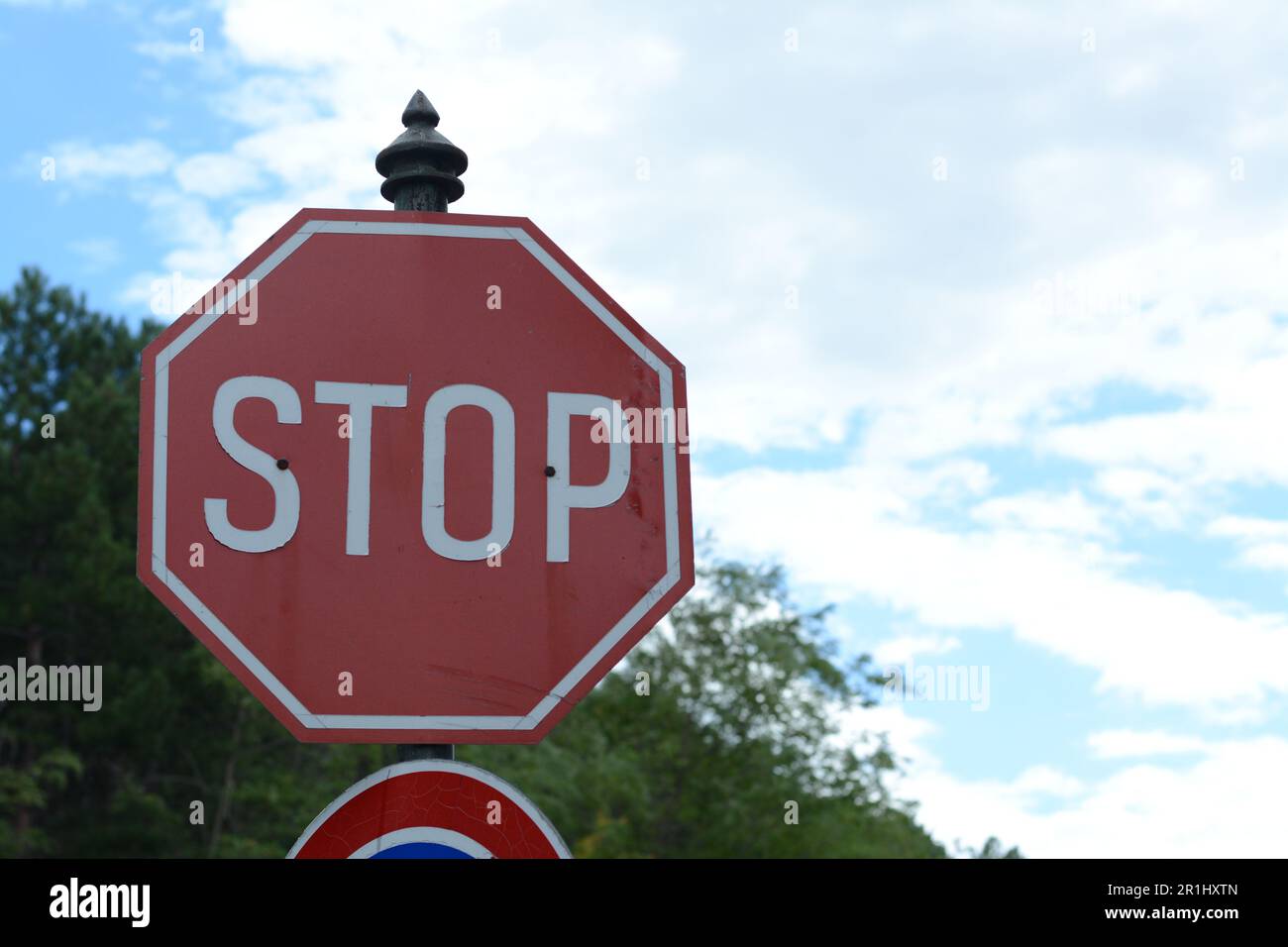 Poster avec panneau Stop contre le ciel bleu Banque D'Images