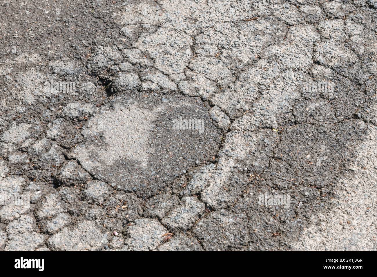 Dommages causés par le gel de la route / présence d'un alligator sur la surface du tarmac, entraînant une formation de pothole sur la route nationale du Royaume-Uni. Pour le concept de l'entretien des autoroutes, la surface de tarmac crasée Banque D'Images