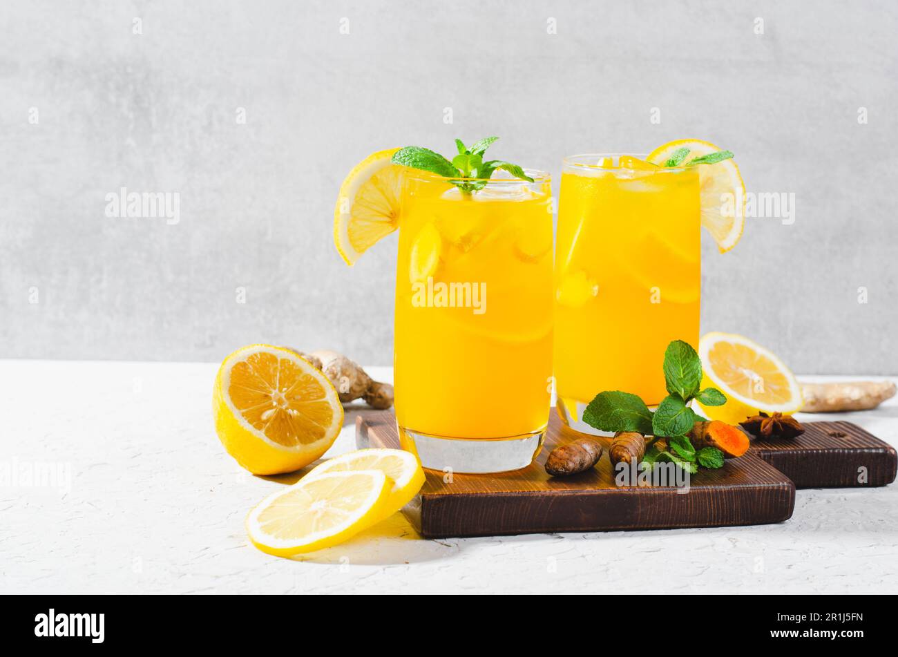 Limonade au gingembre et au curcuma, boisson saine au curcuma et aux épices, jus de Jamu, boisson d'appoint d'immunité sur fond gris clair Banque D'Images