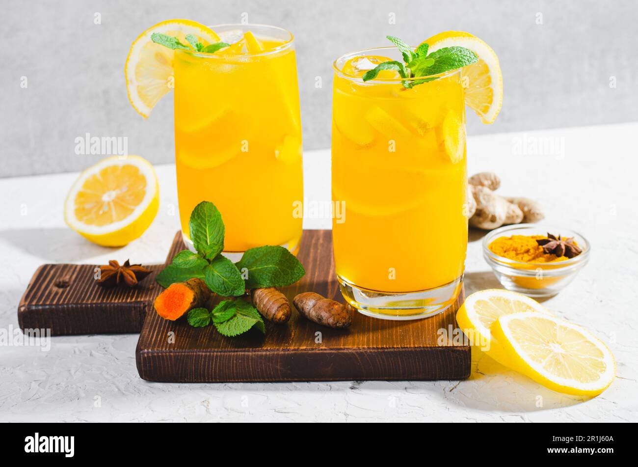 Limonade au gingembre et au curcuma, boisson saine au curcuma et aux épices, jus de Jamu, boisson d'appoint d'immunité sur fond gris clair Banque D'Images