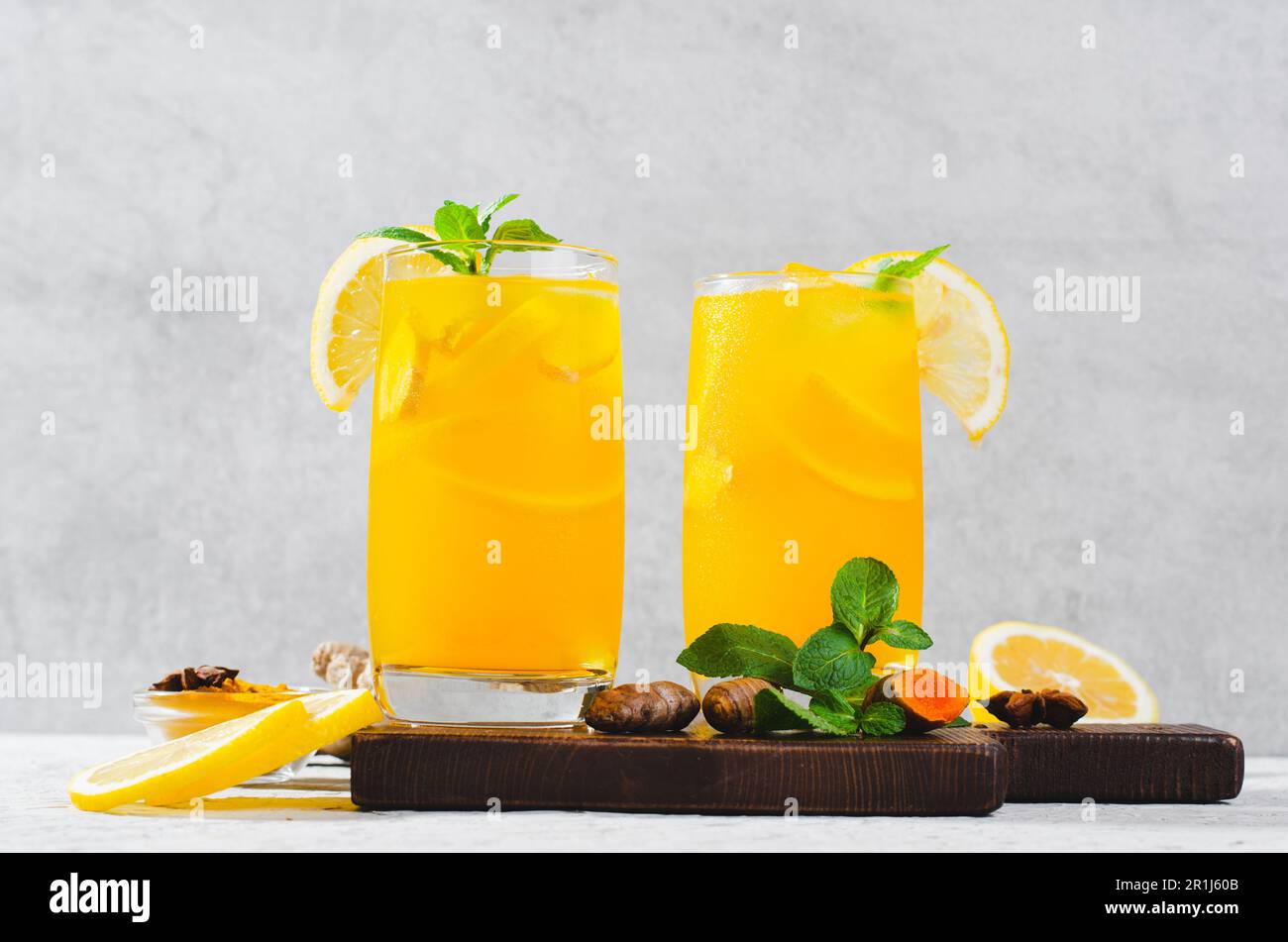 Limonade au gingembre et au curcuma, boisson saine au curcuma et aux épices, jus de Jamu, boisson d'appoint d'immunité sur fond gris clair Banque D'Images