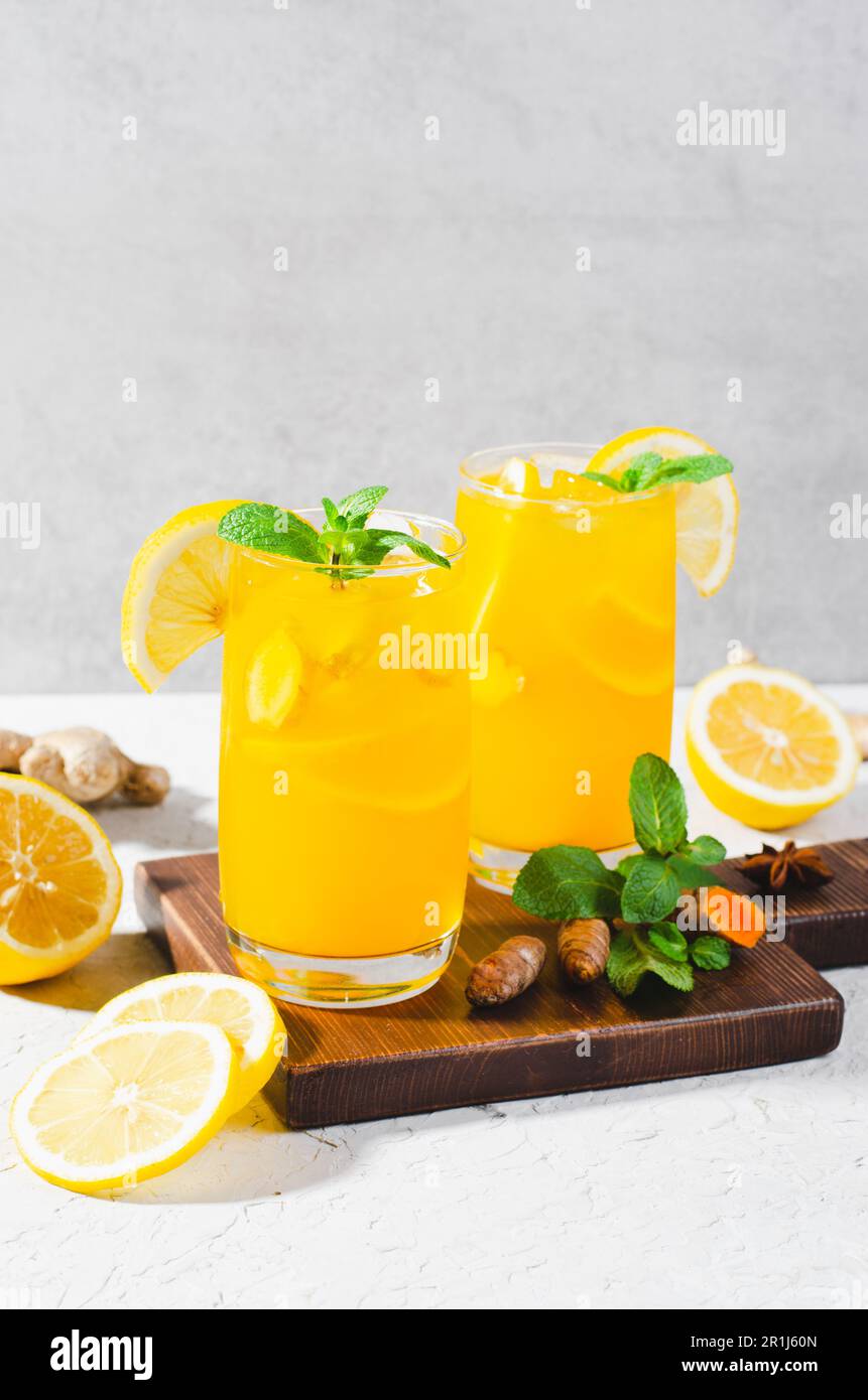Limonade au gingembre et au curcuma, boisson saine au curcuma et aux épices, jus de Jamu, boisson d'appoint d'immunité sur fond gris clair Banque D'Images