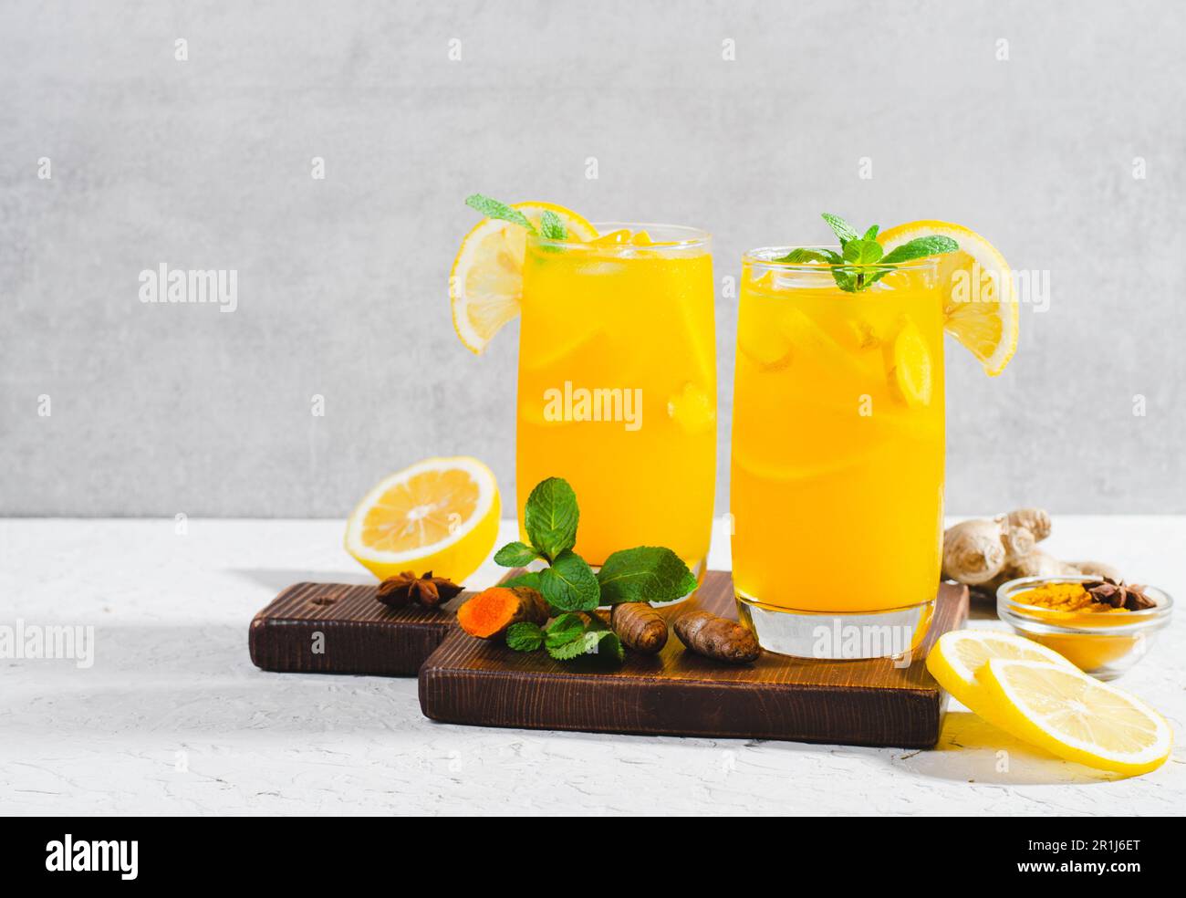 Limonade au gingembre et au curcuma, boisson saine au curcuma et aux épices, jus de Jamu, boisson d'appoint d'immunité sur fond gris clair Banque D'Images