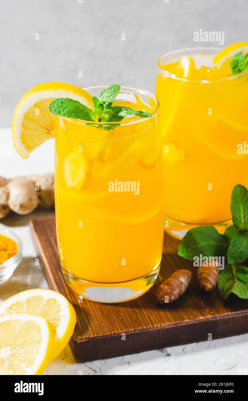 Limonade au gingembre et au curcuma, boisson saine au curcuma et aux épices, jus de Jamu, boisson d'appoint d'immunité sur fond gris clair Banque D'Images
