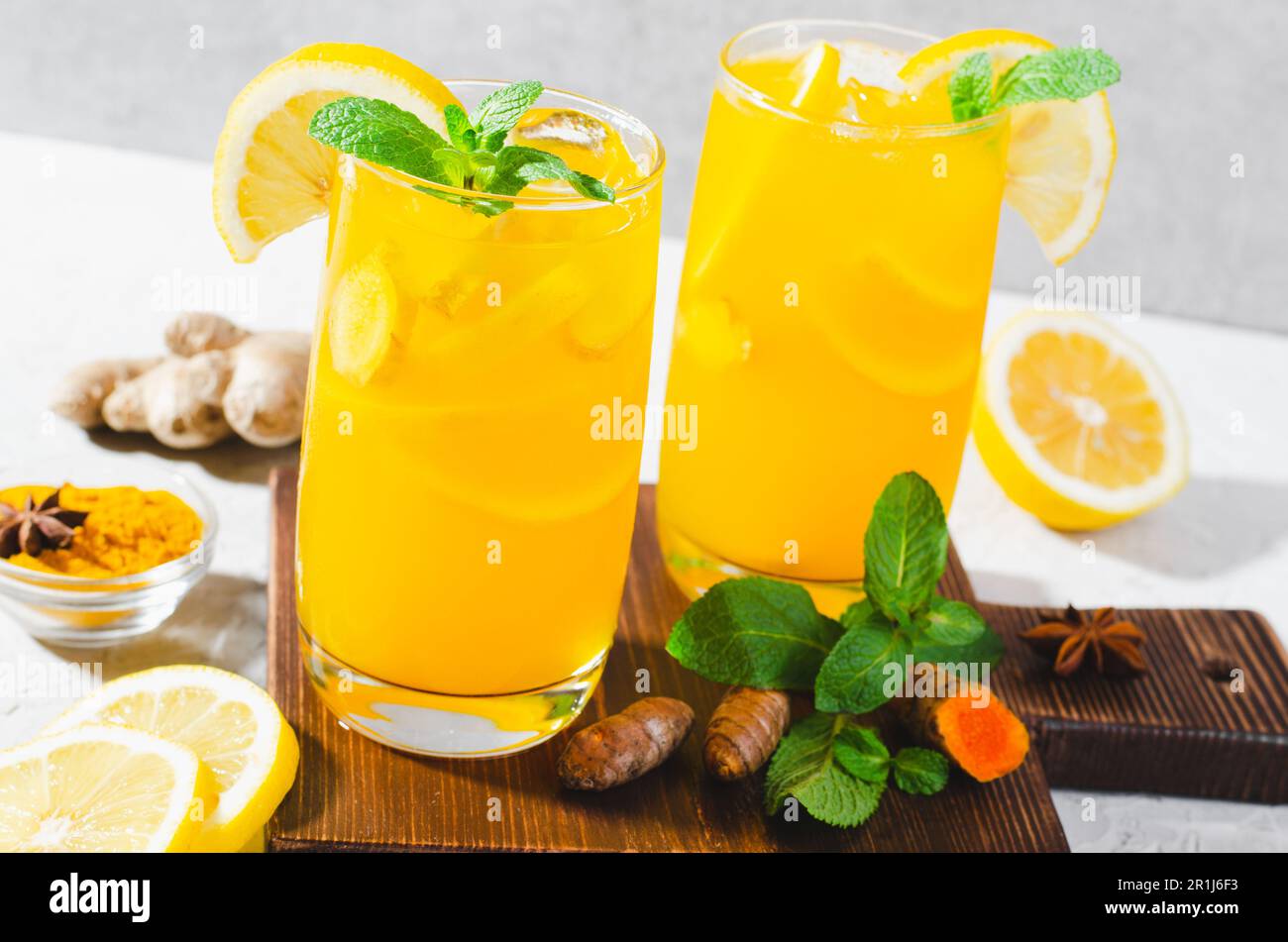 Limonade au gingembre et au curcuma, boisson saine au curcuma et aux épices, jus de Jamu, boisson d'appoint d'immunité sur fond gris clair Banque D'Images