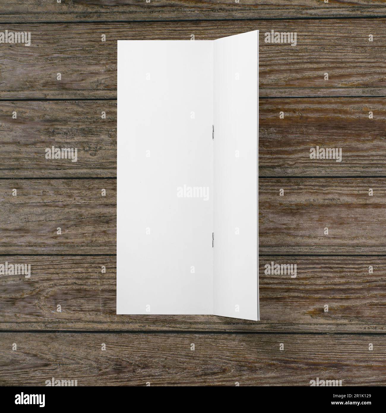 Papier blanc vierge à demi-pli sur fond en bois. Banque D'Images