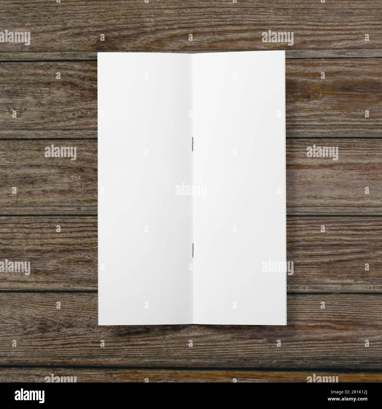 Papier blanc vierge à demi-pli sur fond en bois. Banque D'Images