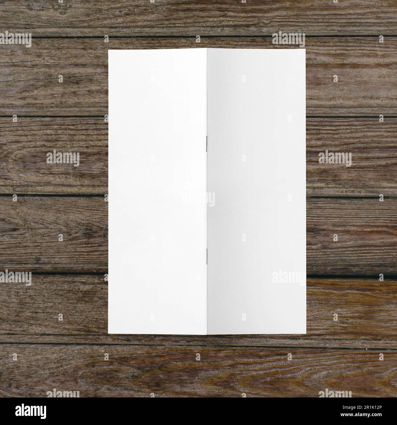 Papier blanc vierge à demi-pli sur fond en bois. Banque D'Images