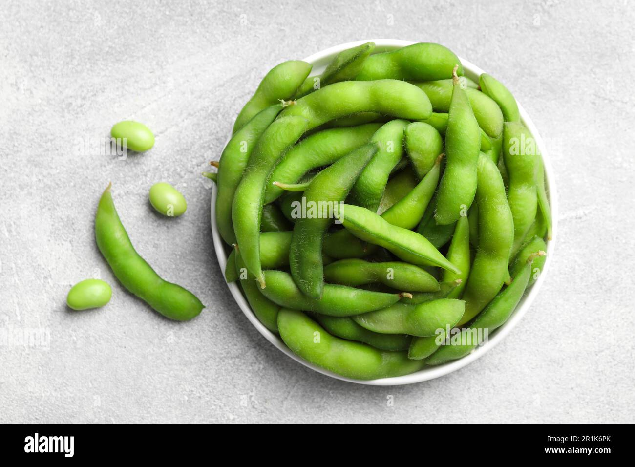 Haricots edamame verts dans les gousses sur la table gris clair, à plat Banque D'Images