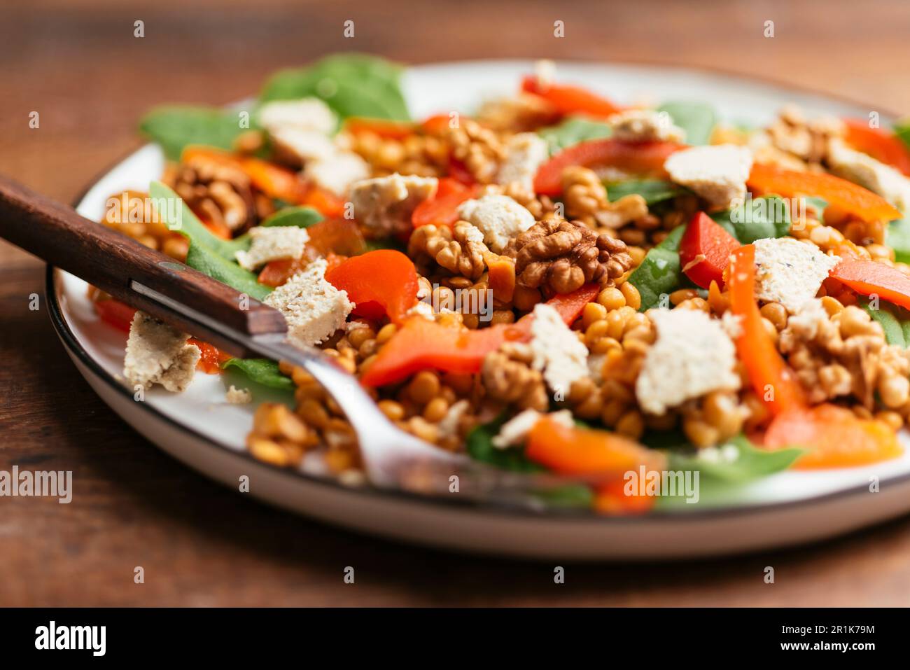 Salade d'épinards et de gentil avec poivrons rôtis, noix de Grenoble et feta de légumes Banque D'Images