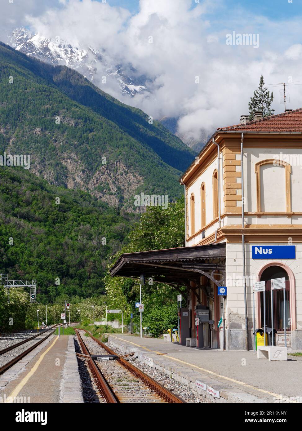 Gare dans la ville de nus, Vallée d'Aoste, NW Italie avec des nuages au-dessus des alpes enneigées. Banque D'Images