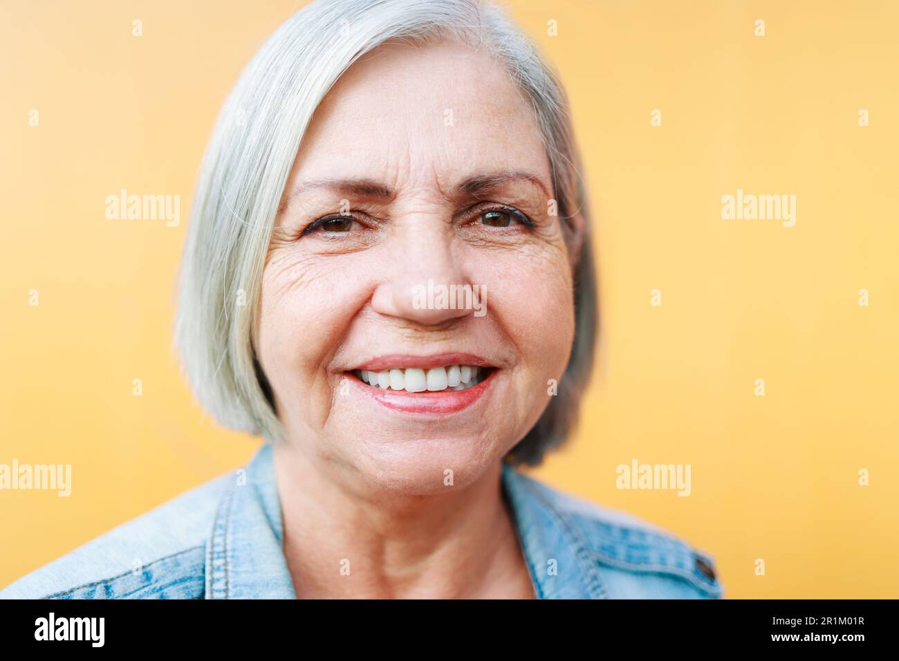Portrait d'une femme âgée heureuse souriant à l'appareil photo - Focus sur les yeux Banque D'Images