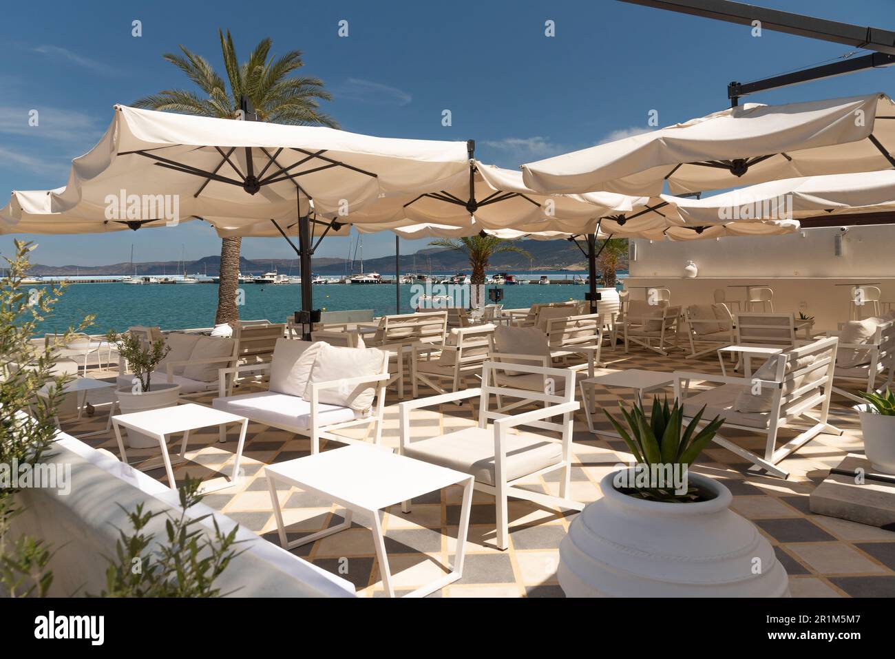 Sitia, Crète, Grèce, Europe. 2023. Début du printemps une journée ensoleillée mais pas de clients assis dans ce café restaurant en bord de mer. Banque D'Images