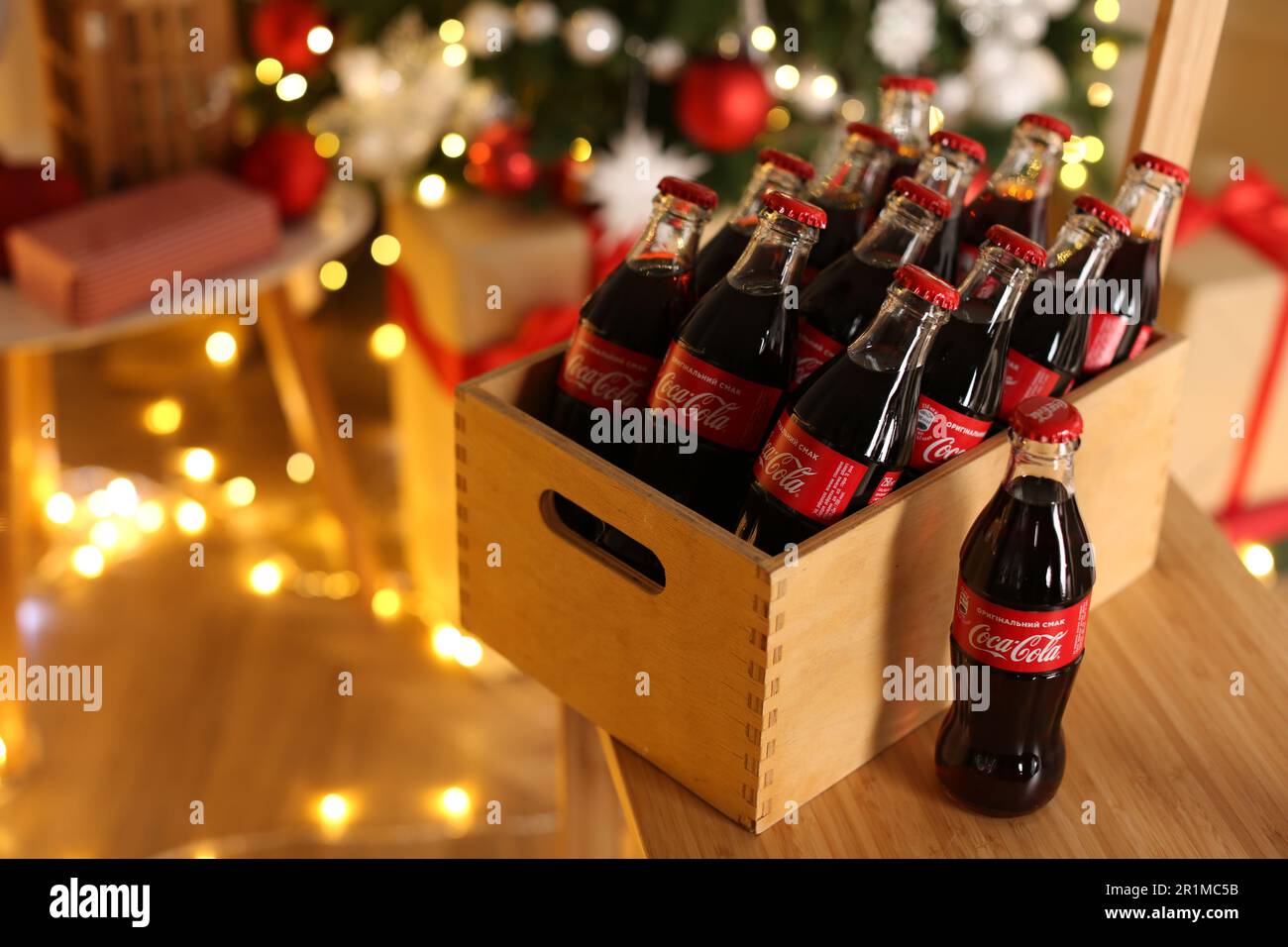 MYKOLAIV, UKRAINE - 18 JANVIER 2021 : caisse en bois avec bouteilles Coca-Cola sur chaise dans la chambre Banque D'Images