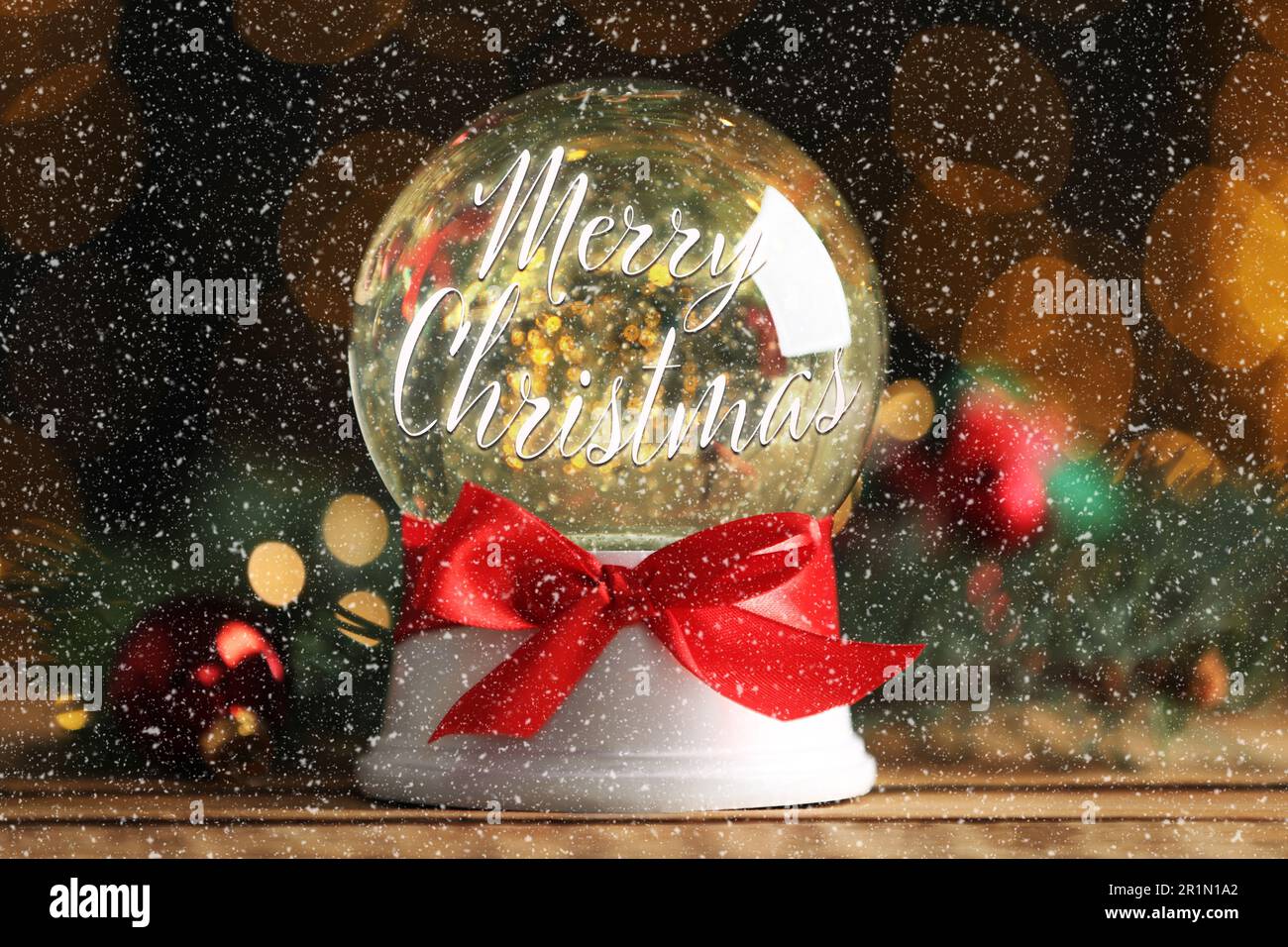 Magnifique boule de neige avec l'expression Joyeux Noël sur table en