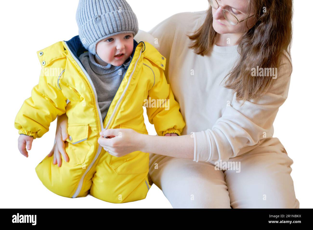 L enfant est vetu de vetements chauds d hiver pour une promenade a l exterieur isole sur fond blanc. Femme mere met des vetements sur bebe garcon pour la petite fille Photo Stock Alamy