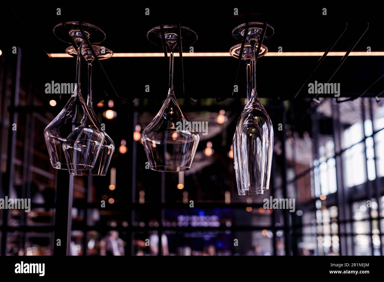 Beaucoup de verres à vin vides accrochés au bar dans un café ou un restaurant. Intérieur sombre Banque D'Images