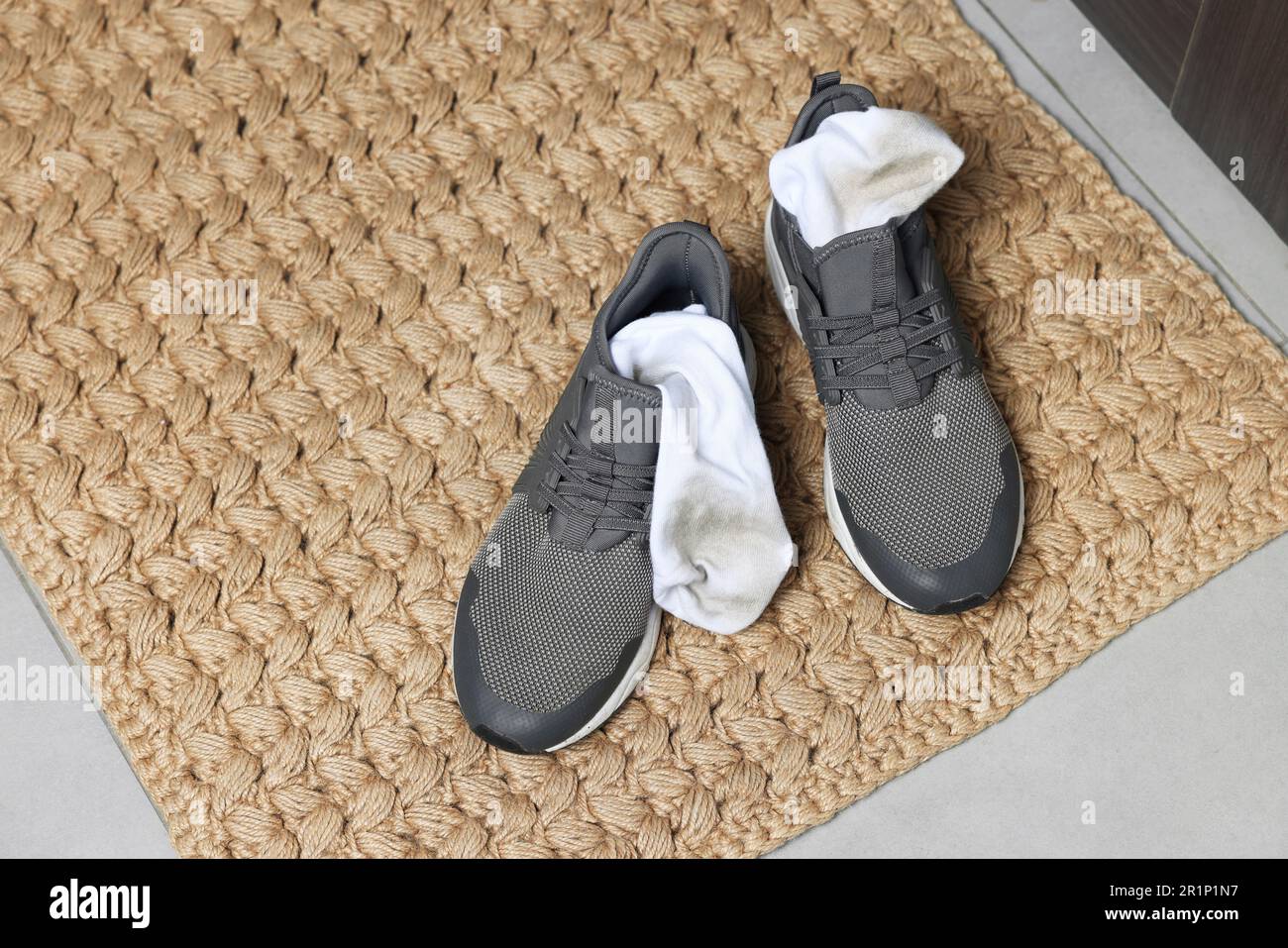 Baskets avec chaussettes sales sur tapis tissé à l'intérieur, gros plan. Espace pour le texte Banque D'Images